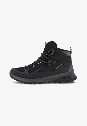 Schwarze wasserdichte Wanderschuhe mit strukturiertem Obermaterial, Gummisohle und reflektierenden Akzenten. Verfügt über ein High-Top-Design mit Schnürsenkeln.