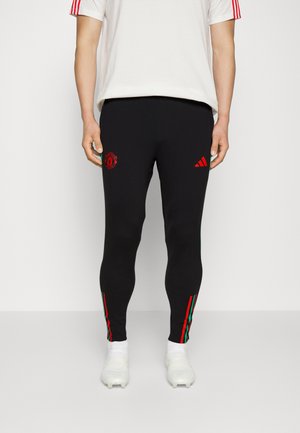 Black athletic leggings with a fitted design, featuring red embroidered logo and green/red side stripes, made from smooth, stretchy material.