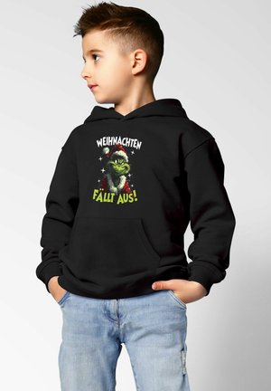 Black hoodie featuring a front graphic of a green character in a red and white Santa hat. Text reads "WEIHNACHTEN FÄLLT AUS!" in white and green.