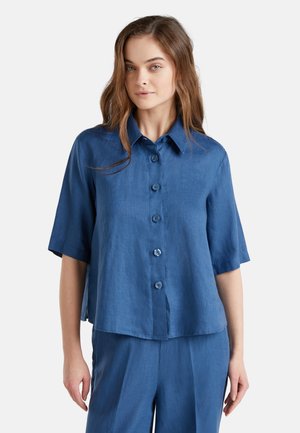 Chemise à manches courtes, boutonnée, en lin bleu léger, avec un col, cinq boutons et une coupe décontractée avec un ourlet légèrement arrondi.