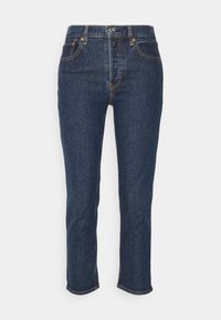 Jeans en denim bleu foncé avec une coupe droite, présentant des accents en métal doré, des poches avant et un ourlet brut aux chevilles.