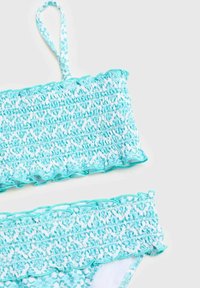 Tyrkysový bikiny top so zúženými okrajmi a nastaviteľným ramienkom, doplnený o zodpovedajúce bikiny nohavičky so zúžením; kvetinový vzor.