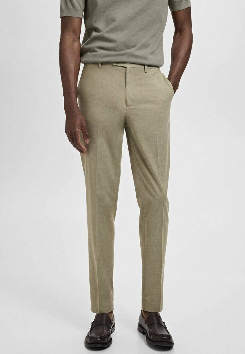 Beige skräddarsydda byxor i lättviktsmaterial, med flat front, sidofickor och slim fit. Matchade med mörka loafers.