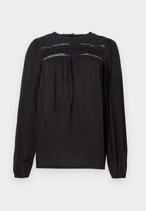 Blusa preta de manga longa com decote redondo, apresentando detalhes em franzido e tecido pregueado na área do busto e mangas. Textura suave.