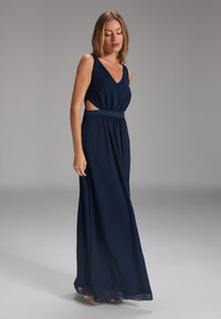 Navyblaues Maxikleid mit tiefem V-Ausschnitt, Cut-Out-Details an der Taille, plissiertem Stoff und glatter Textur. Verstellbare Taille.