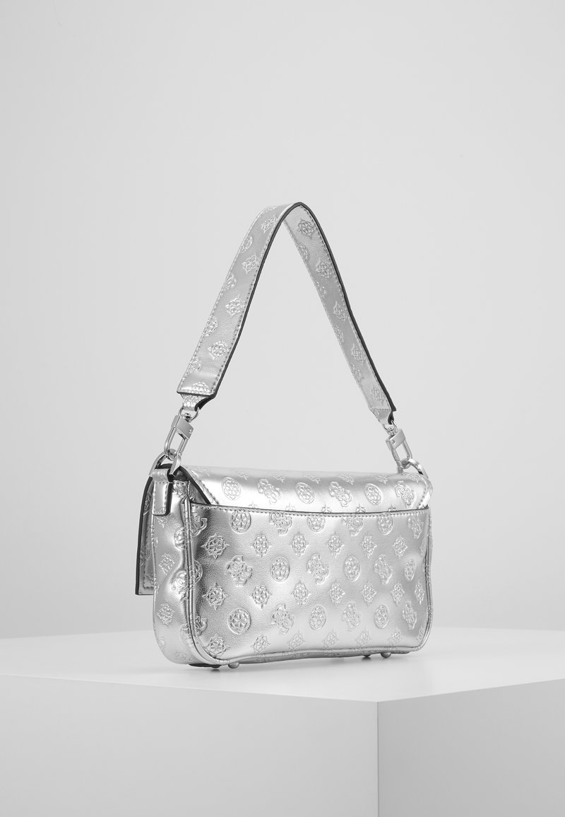 Silberne Handtasche mit geprägten dekorativen Mustern, flache Form, verstellbarer Tragegurt und metallischer Oberfläche, auf einem neutralen Hintergrund präsentiert.