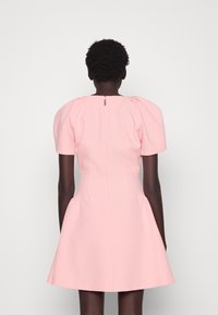 Rosa Kleid mit kurzen Puffärmeln, tailliertem Oberteil und ausgestelltem Rock. Hergestellt aus glattem Stoff und mit einem verdeckten Reißverschluss auf der Rückseite.