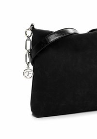 Borsa a tracolla nera in ecopelle, con design piatto, tracolla lucida e dettagli in metallo argentato, impreziosita da un charm decorativo con logo.