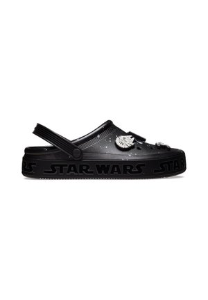 Crocs noirs avec une bride réglable, logo Star Wars sur la semelle, et breloques à thème Millennium Falcon et Star Wars sur le dessus.
