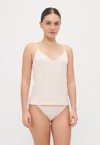 Lys rosa singlet med tynne stropper og v-hals, med strukturerte ribbede detaljer og blondekant langs kantene. Sammen med matchende truser.