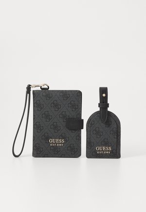 Tarjetero negro de cuero sintético con patrón de logo y letra dorada, acompañado de una etiqueta de equipaje a juego con un lazo de sujeción.