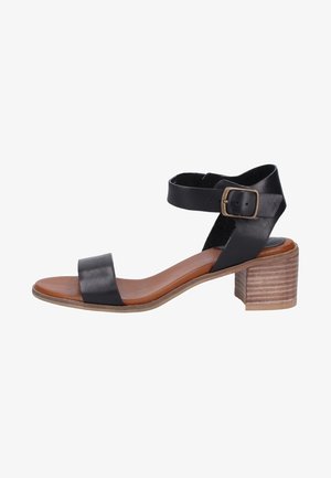 Black leather sandal with two straps, one ankle strap featuring a buckle. Brown wooden block heel and smooth, light brown insole.