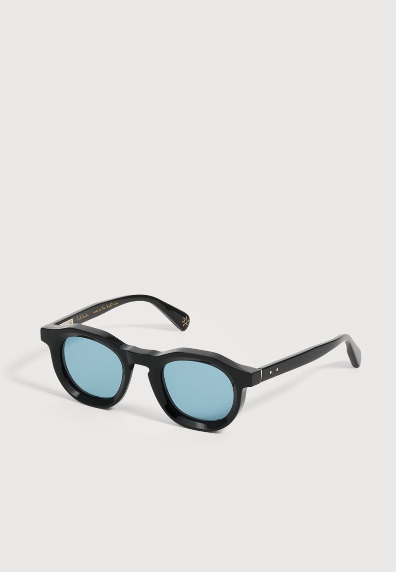 Lunettes de soleil à monture noire avec des verres ronds teintés en bleu, branches pliées et un détail doré discret à l'intérieur de la branche droite.