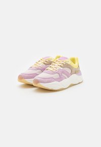 Purple and beige sneakers with mesh and suede materials, featuring a yellow inner lining, round toe, and textured outsole.