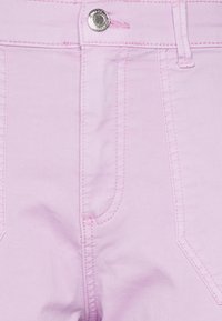 Calças de ganga rosa claro com fecho de botão, costura tonal e bolsos dianteiros com costuras distintas. Textura suave e ajuste moderno.
