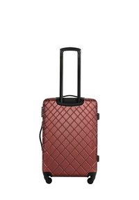 Valigia rigida rossa con motivo a diamante, manico telescopico nero e quattro ruote per la mobilità. Presenta una zip esterna e un manico laterale.