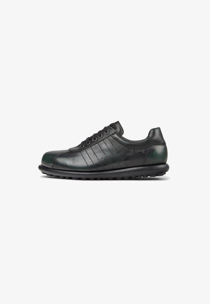 Scarpa in pelle nera con punta arrotondata, pannelli laterali testurizzati e cinque occhielli. Presenta una suola in gomma con piccole scanalature per garantire la trazione.