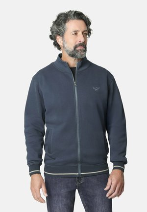 Chaqueta de cremallera en un azul marino oscuro, hecha de una tela suave, con un cuello alto, bolsillos laterales y puños acanalados con rayas en contraste.