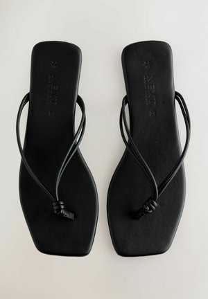 Juodos plokščios šlepetės minimalistiniu dizainu, turinčios ploną dirželį ir plokščią pėdą. Pagamintos iš lygaus medžiagos su subtilia tekstūra.