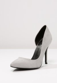 Décolleté grigio in suede con punta affusolata, design d'Orsay, tacco slanciato, texture morbida e rivestimento interno nero.