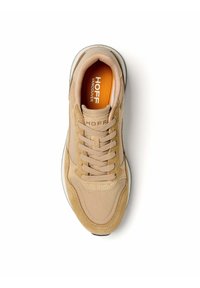 Zapatilla beige con materiales de malla y ante, que presenta un diseño con cordones, un collar acolchado y un detalle de plantilla en contraste en naranja.