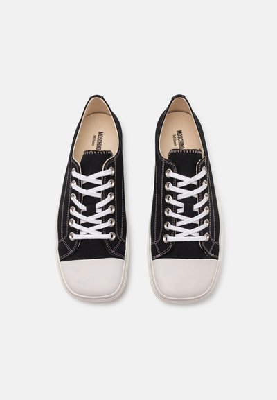 Sneaker nere in tela con lacci bianchi, suole in gomma e cuciture a contrasto. Punta arrotondata, design piatto e logo sulla soletta.