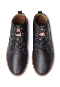 Zapatos de cuero negro con cordones, con superficie texturizada, puntera redonda y suela de goma marrón. Presentan ojales metálicos y un logotipo en la lengüeta.