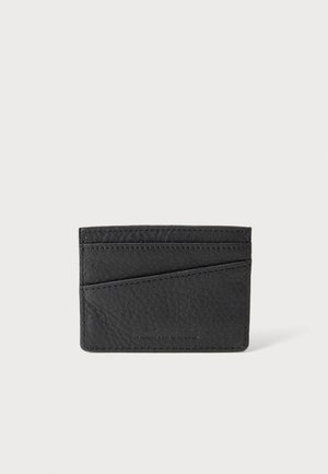 Porte-cartes en cuir noir texturé avec trois emplacements horizontaux pour cartes et un marquage embossé subtil sur fond clair.