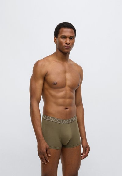 Λαδί κάλτσες μποξέρ με υφή στη γκρι ζώνη μέσης με διακριτικό σχέδιο. Μαλακό ύφασμα, εφαρμοστή γραμμή και μήκος μέχρι το μέσο του μηρού.