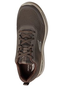 Chaussure de sport marron avec une tige en mesh, des lacets plats et un col rembourré. Elle possède une semelle texturée et un logo discret sur le côté.