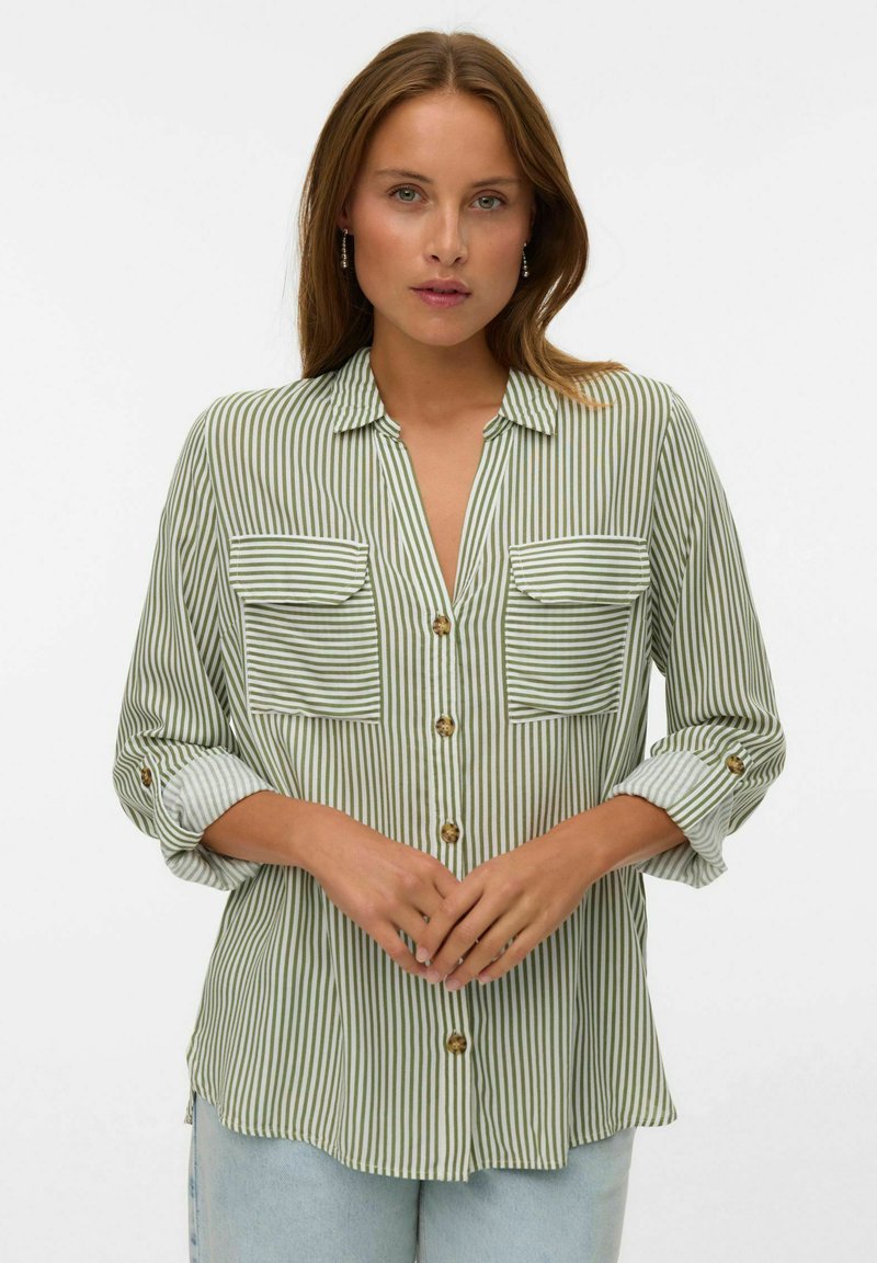Camicia a righe verdi con due tasche sul petto, chiusura con bottoni, maniche arrotolate e una vestibilità comoda con una texture morbida.