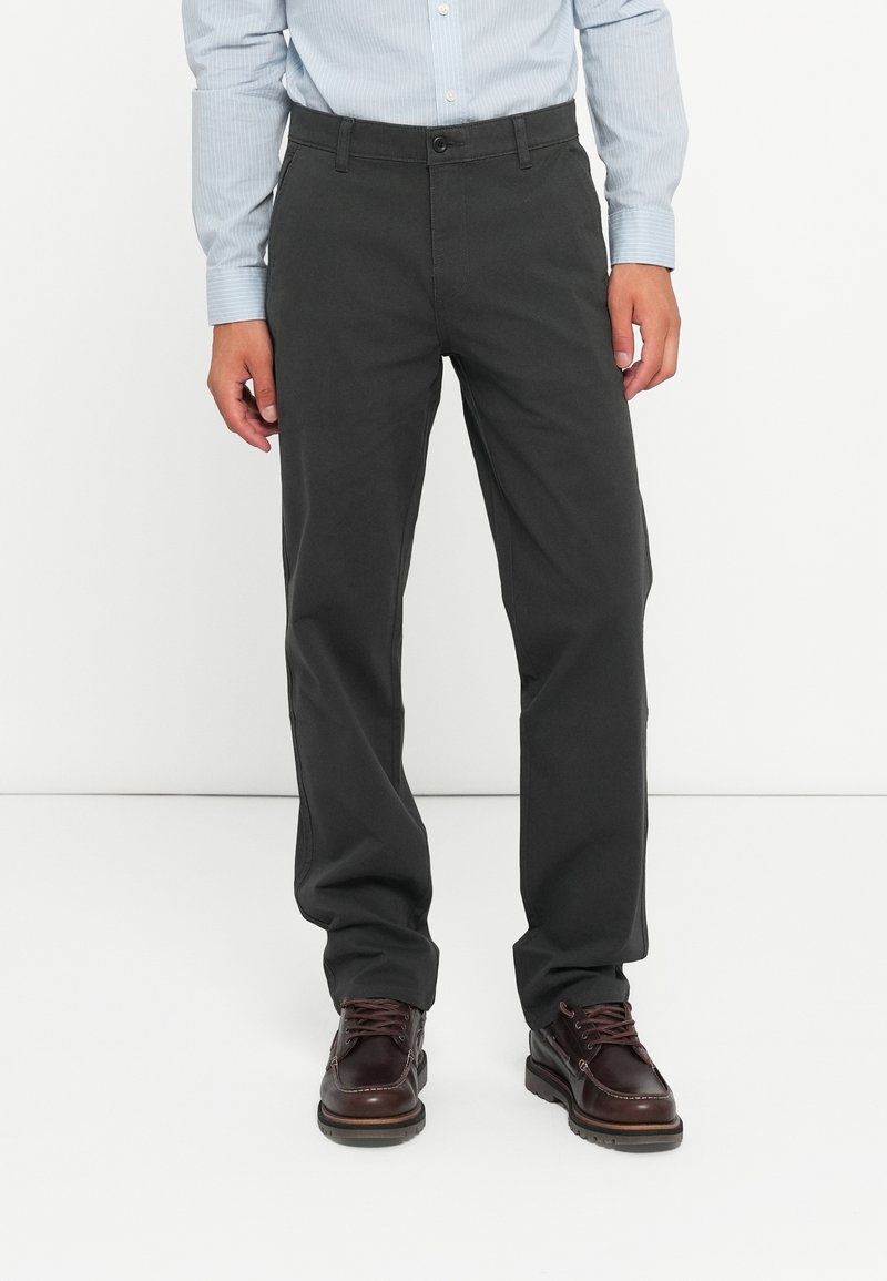 Gray, straight-leg trousers made of cotton blend, featuring a button closure and side pockets, paired with dark brown lace-up shoes.