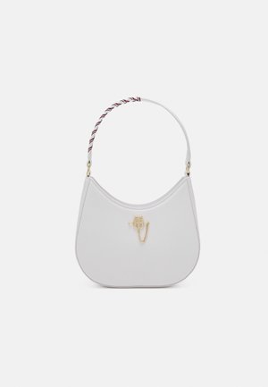 Sac à main blanc à bandoulière à la forme incurvée, logo doré et détail chaîne, avec une sangle torsadée de fils rouges, noirs et blancs.