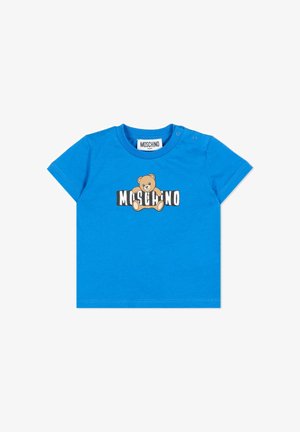 Niebieska dziecięca koszulka z nadrukiem misia siedzącego na wyrazistym napisie "Moschino" na klatce piersiowej, z zatrzaskami na ramieniu.