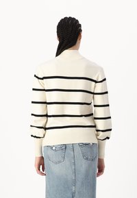 Cremfarbener Strickpullover mit schwarzen horizontalen Streifen, gerippten Bündchen und hochgeschlossenem Kragen. Entworfen mit einer lässigen Passform und strukturiertem Stoff.