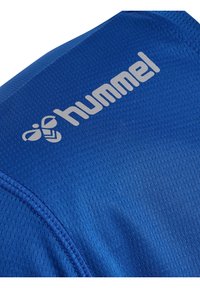 Blauw sportshirt van gestructureerde stof, met een zilveren "hummel"-logo en een patroon. Close-up van het schoudergebied.