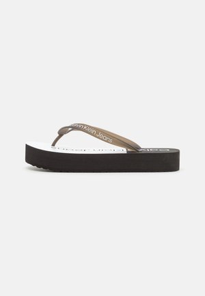 Czarno-białe klapki na platformie z brązowymi przezroczystymi paskami z logo "Calvin Klein Jeans" na paskach i wkładce.