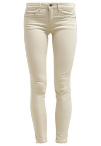 Jeans skinny beige hechos de una mezcla de algodón con una cintura de altura media, bolsillos frontales y una textura suave, ligeramente brillante.