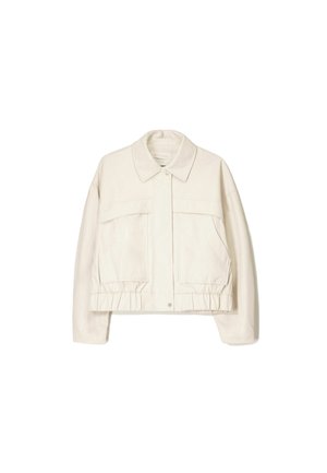 Veste en denim blanche avec un col, poches avant, ourlet élastiqué et manches longues. Texture lisse et design minimaliste.