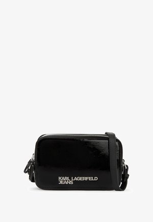 Juodas lakinės odos kryžminių maišelių krepšys stačiakampio formos, su užtrauktuku ir sidabriniu logotipu priekyje. Pridedamas reguliuojamas dirželis.