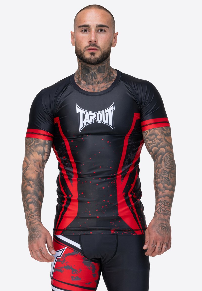 Rash guard ajustado negro y rojo con el logo de TAPOUT, que presenta un diseño de mangas cortas, patrón de salpicaduras y rayas en contraste.