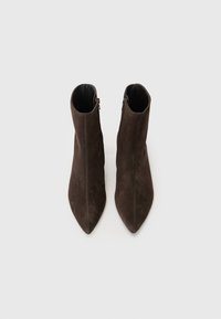 Brune semskede ankelstøvler med spids tå, med en sidelukning og glat inderside. Slank, elegant design.