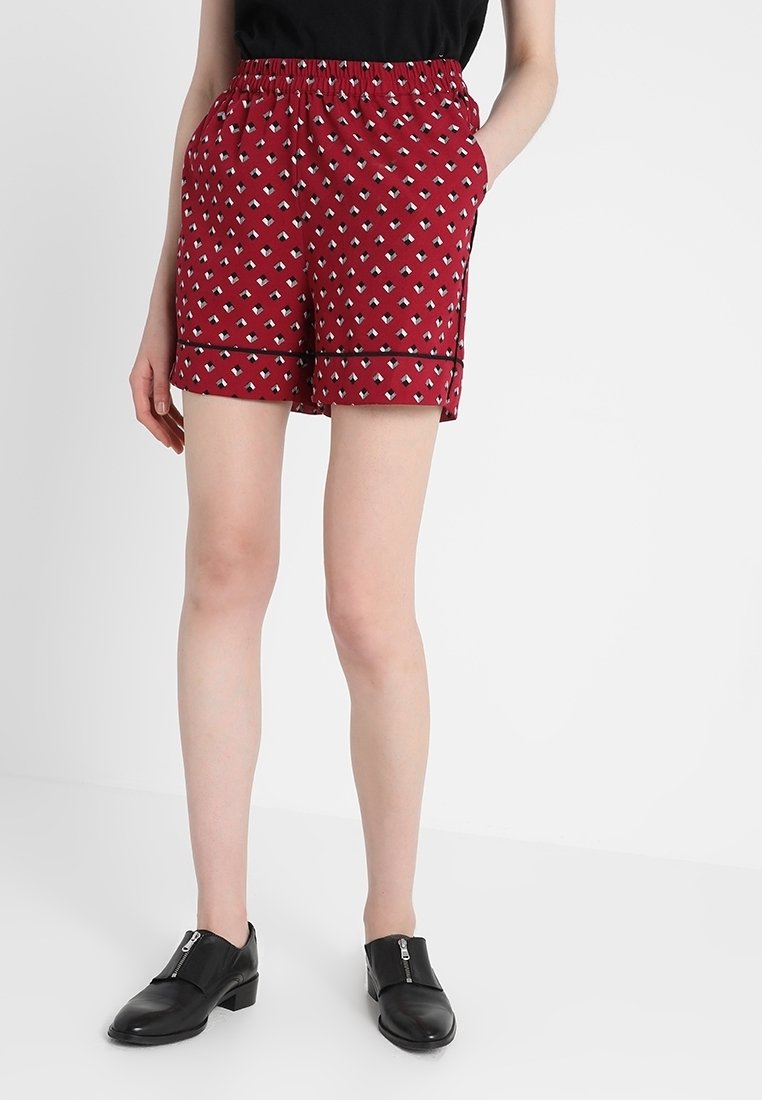 Patterned maroon shorts with an elastic waistband, featuring a geometric design in blue and white, and side pockets. Black trim accents.