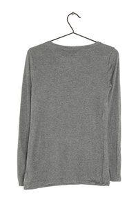 Graues Langarmshirt aus weichem Material, mit rundem Halsausschnitt und seitlicher Nahtdetails. Hängt an einem schwarzen Haken.