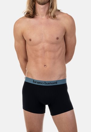 Black boxer briefs made of soft fabric, featuring a blue elastic waistband with "bruno banani" printed in black. Simple design, no patterns.
