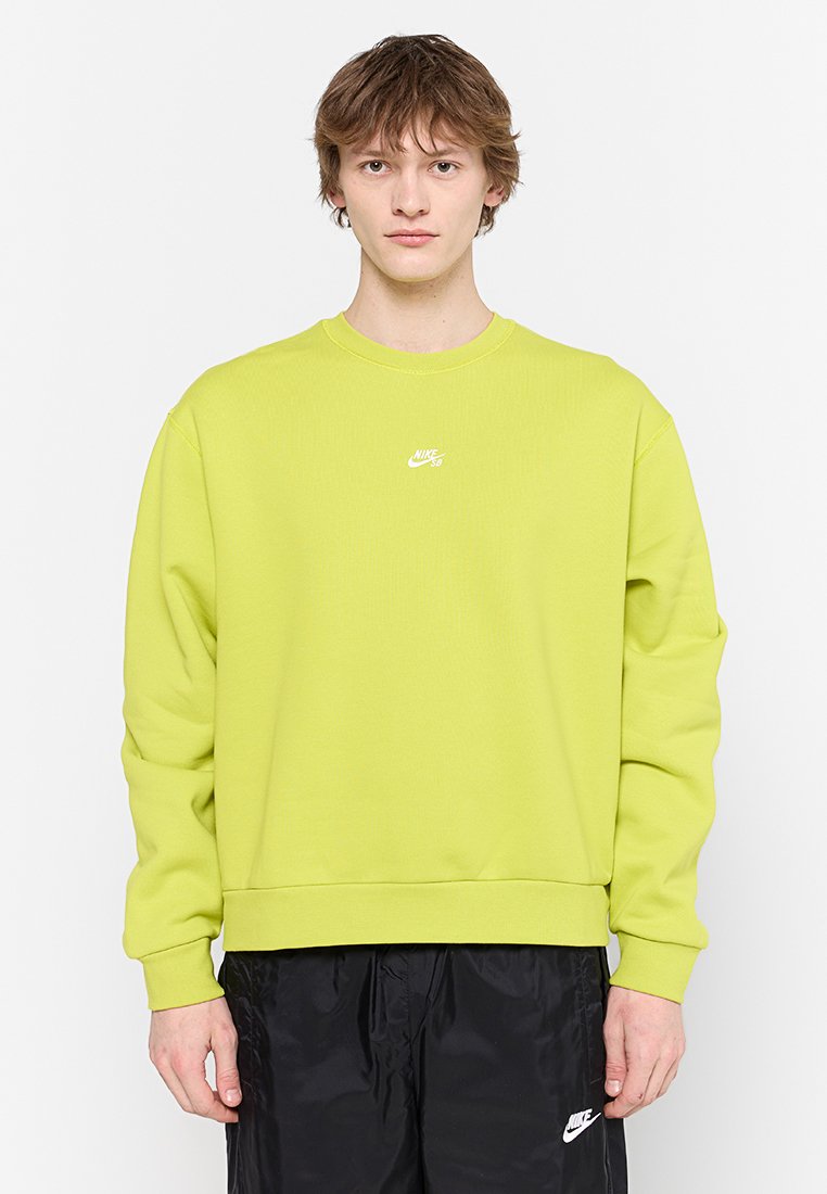 Sudadera de color verde lima con cuello redondo, mangas largas y un logo blanco de Nike en el pecho. La tela parece suave y texturizada.