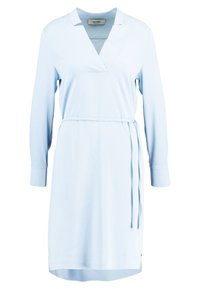 Vestido azul claro con escote en V, mangas largas y cintura anudada. Hecho de material suave con corte recto y aberturas laterales.