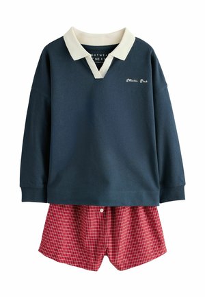 Granatowa koszulka polo z długim rękawem, białym kołnierzem i napisem „Athletic Club”, połączona z czerwonymi szortami w kratę z przednim guzikiem.