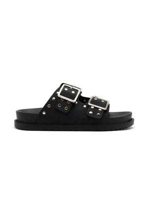 Chanclas negras de ante, con dos correas ajustables y hebillas cuadradas de plata, adornadas con tachuelas metálicas a lo largo de los bordes.