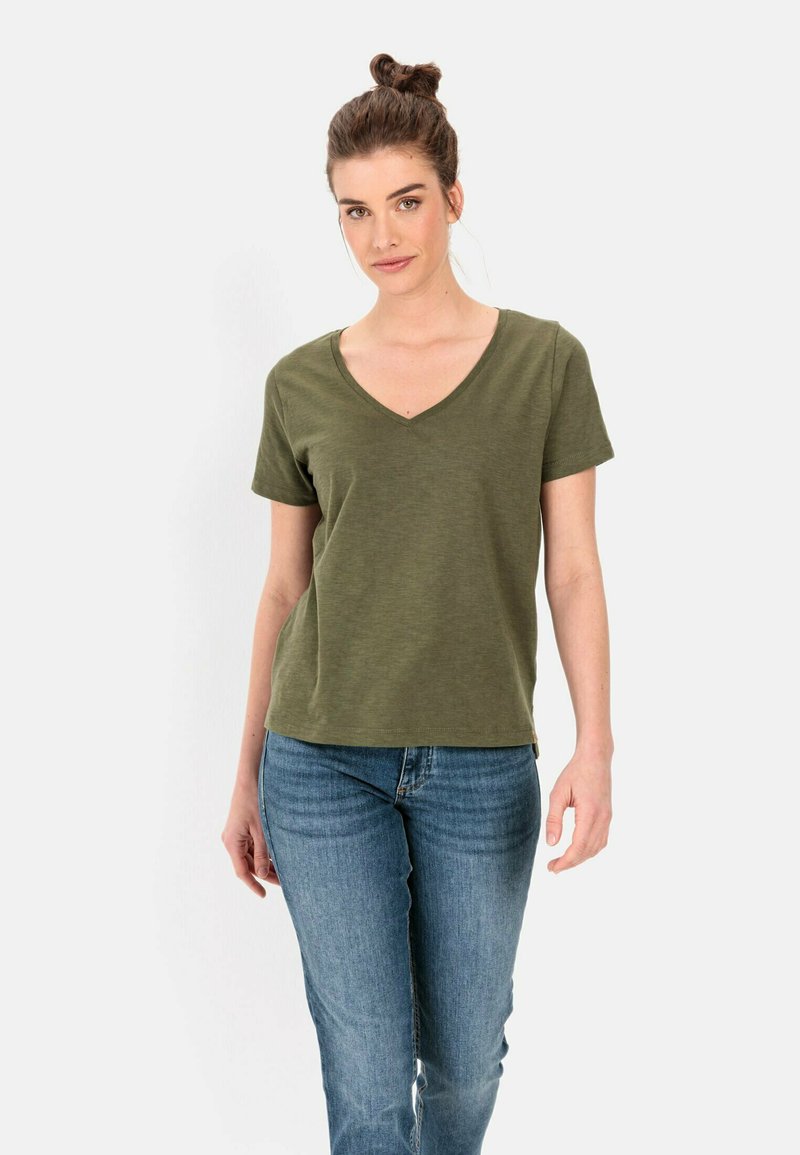 Olijfgroen T-shirt met korte mouwen en V-hals, gemaakt van zachte, gestructureerde stof. Combineert met lichtblauwe spijkerbroek, weergegeven op een neutrale achtergrond.